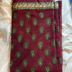 Maroon sari with green thread work all around.